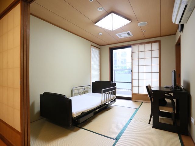 和室タイプの居室 居室 落ち着いた雰囲気の和室で、窓からは自然光が差し込んでいます。必要な備品が整い、ゆったりとした時間を過ごせる空間です。