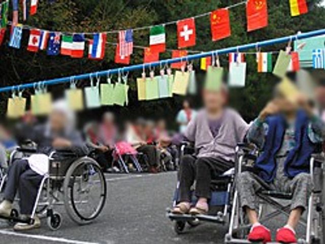 各国の旗が並ぶ風景 中庭 各国の旗が華やかに飾られたイベント中の風景です。利用者の方々がリラックスしています。