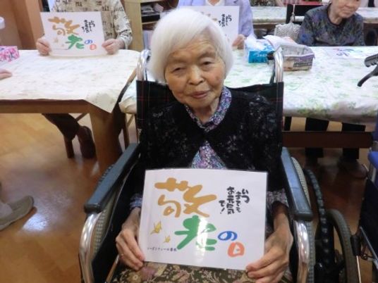 笑顔の高齢者と手作り看板