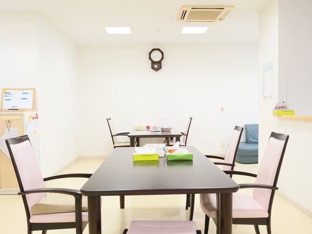 明るい共有スペースのテーブルと椅子 共有スペース ゆったりと配置された椅子とテーブルがある、清潔感のある共有スペースです。時計の近くで、ゆっくりと時間を過ごすことができそうです。