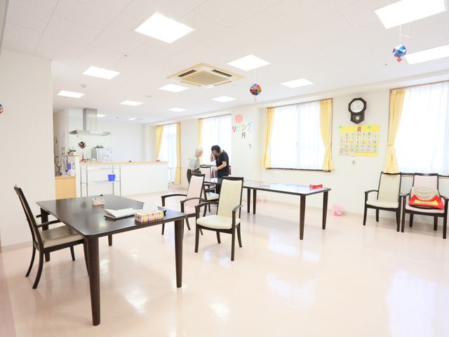 共有スペースの日常風景 共有スペース 広々として清潔感のある共有スペースでは、二人の方が何やら楽しそうに活動しています。ゆったりとした時間が流れる場所で、日々の暮らしや交流が広がっていくでしょう。