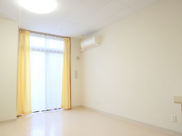 明るい居室の一角 居室 天井が高く、ゆとりある空間のお部屋です。窓からは自然光が差し込み、暖かな雰囲気を感じられます。