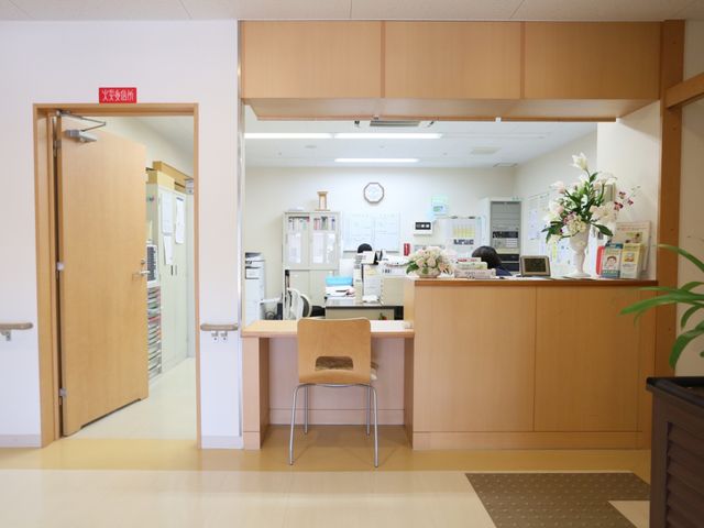 フラワー装飾のフロントエリア 受付 清潔感のあふれるフロントは、美しい花で彩られており、勤務中のスタッフが作業をしています。皆さんのご来訪を心よりお待ちしております。