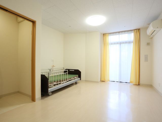 居室のきれいな様子 居室 広々とした居室には必要な設備が整い、落ち着いた色合いのカーテンが温かみのある空間を演出しています。