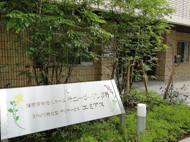 中庭の緑と看板 館銘板 自然に囲まれた中庭では、心地よい緑が訪れる方を癒します。明るい日差しと共に新しい職場でのスタートを想像してください。
