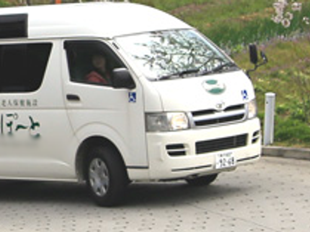 迎えの車がある玄関 エントランス 迎えの車が施設前に停車中です。快適な移動をサポートしています。