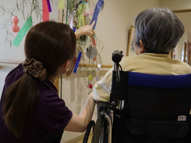 会話の様子の廊下 廊下 利用者とスタッフが会話を楽しんでいます。心温まるひとときに安心感があります。
