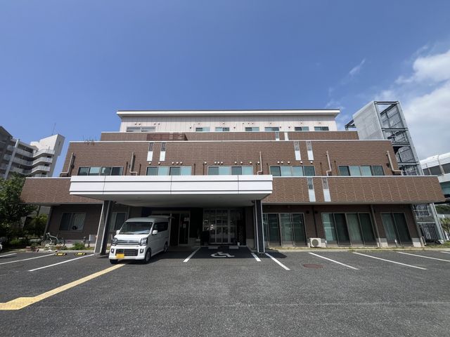 介護施設の外観 外観   青空の下に広がる、落ち着いた色合いの建物です。車寄せがあり、送迎時の出入りもしやすそうです。