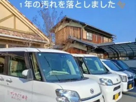 施設の送迎車が並ぶ外観  