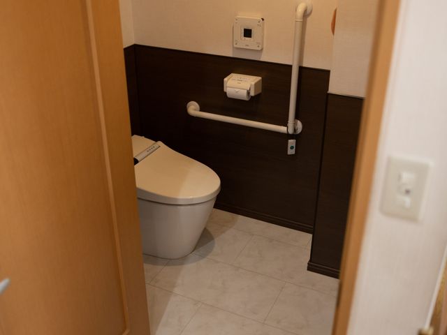 手すり付きのトイレ トイレ 手すりが設置され、安全性に配慮したトイレ空間です。快適さと安心感を重視しています。