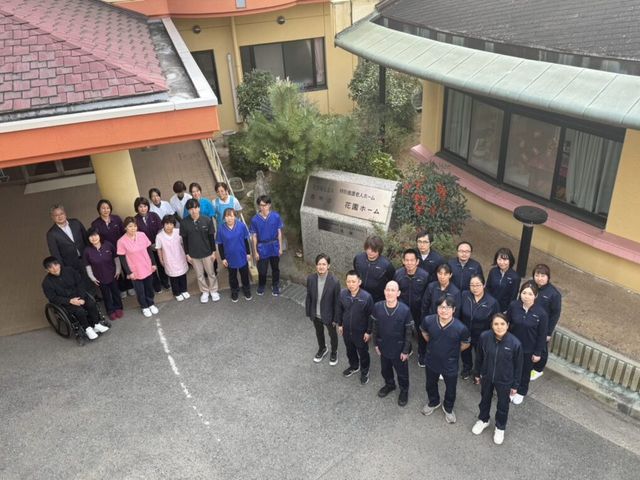 施設のスタッフと看板 看板 笑顔のスタッフが揃い、働きやすい環境が伝わる集合写真です。温かな雰囲気が魅力です。