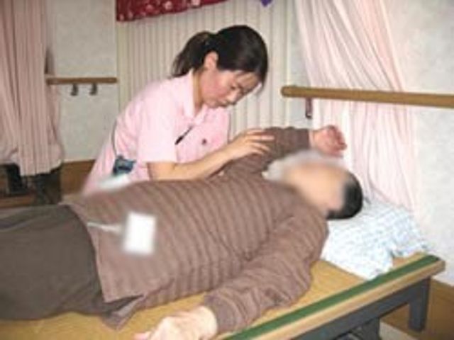 ケアを受ける人の様子 居室 スタッフが利用者の方に丁寧に対応しています。安心して過ごせる温かい場所です。