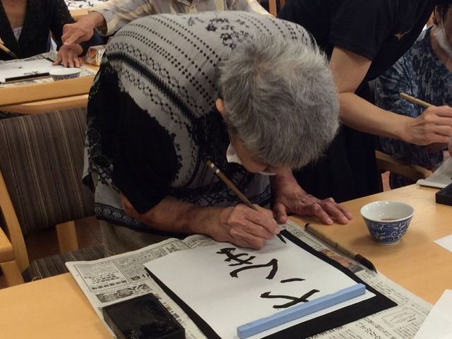 書道を楽しむ人々 多目的室 広々とした多目的室では、書道などのアクティビティを通じて楽しい時間を過ごせます。