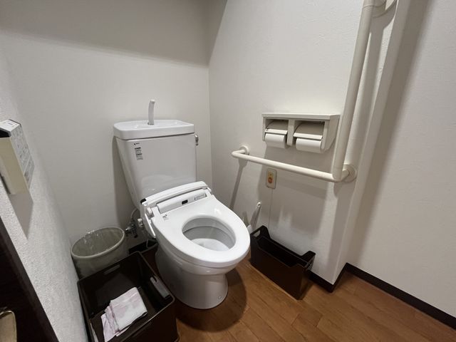 手すり付きのトイレ トイレ   手すりが備わった、出入りしやすい個室のトイレです。床面がすっきりしており、動線を確保しやすそうです。