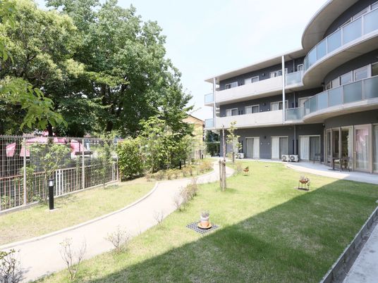 緑豊かな庭のある建物外観