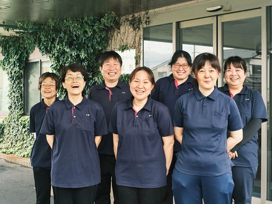 笑顔のスタッフが並ぶ外観  