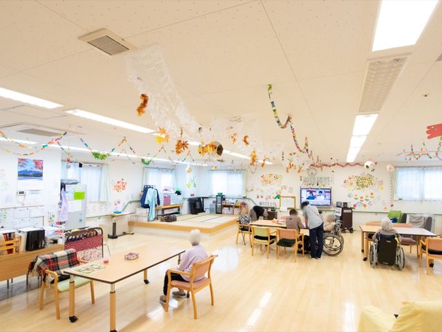 多目的室の賑やかな様子 共有スペース 明るく広々とした共有スペースです。様々な活動や、リラックスしてテレビを観ることもでき、居心地の良い時間を過ごせます。