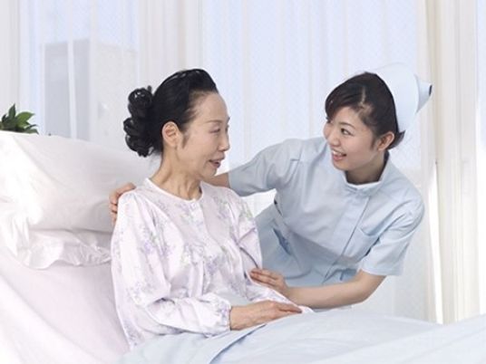 介護士と高齢女性の居室