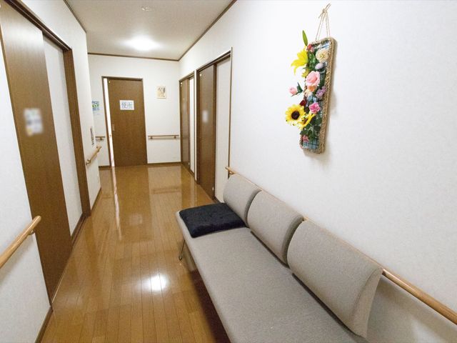 廊下に設けられたベンチ 廊下 手すりが付いた清潔感のある廊下には、待ち合わせに便利なベンチも設置されています。明るく開放的な雰囲気で、来訪者をお迎えします。