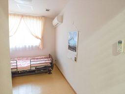 明るい居室の壁とベッド