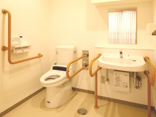手すり付きのトイレ トイレ 使いやすさを考慮した造りが特徴のトイレです。手すりが設置され、安全に配慮されています。