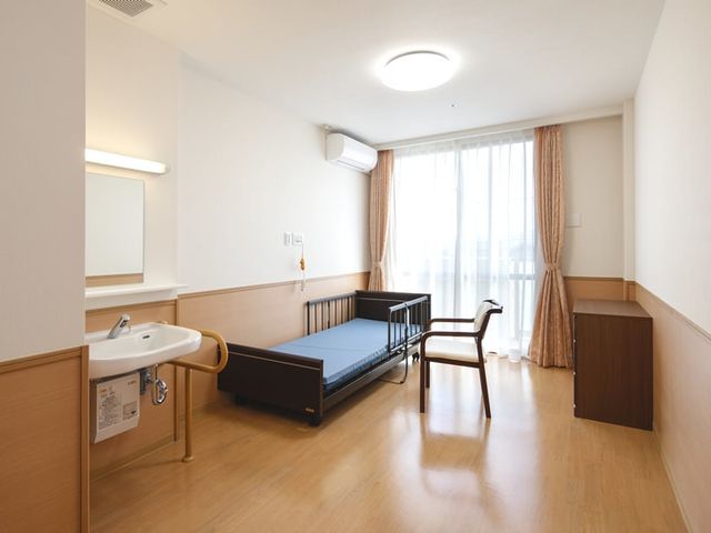 ベッドと窓の居室 居室 広々とした居室には大きな窓があり、自然光がたっぷりと差し込みます。リラックスした時間が過ごせます。
