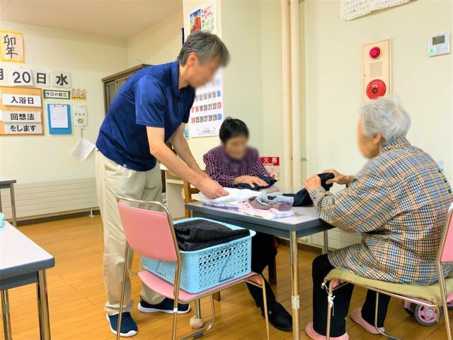 談笑する場面の部屋 機能訓練室 落ち着いた雰囲気の中で、スタッフが穏やかに話しかけ、利用者との交流を深める場面です。
