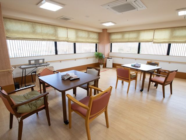 多目的に使える広々とした空間 共有スペース ゆったりとした明るい多目的室で、日々の憩いの場としてご利用頂けます。窓際に配置された植物が心地よいアクセントを加えています。