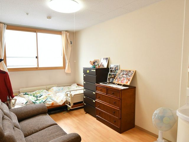 個室の様子 居室 大きな窓から自然光が差し込み、明るい雰囲気の個室です。落ち着いた家具が配置されています。