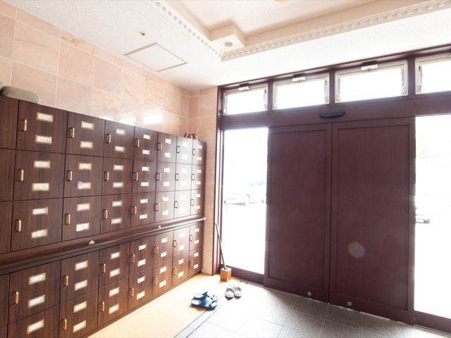 エントランスの靴箱と扉 玄関 落ち着いた雰囲気のエントランスには、整然とした靴箱が配置されており、出入りの際の快適さが考慮されています。