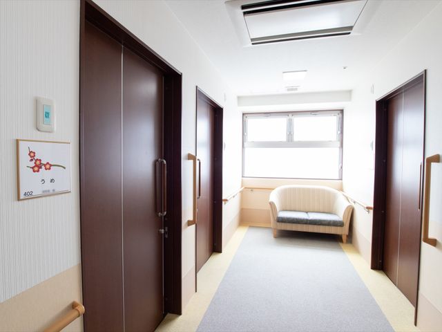 廊下の清潔な空間 通路 開放的な窓とソファが配置された明るい廊下です。職員が利用者様への配慮を行いやすい設計になっております。