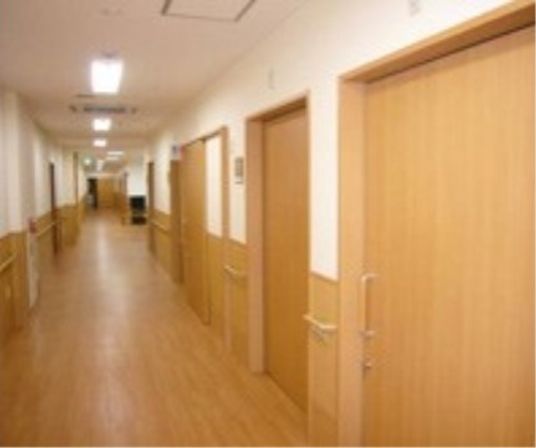 白と木目を基調とした廊下スペースは、ぬくもり感漂う空間である。すべての壁に手すりを完備し、安全性にも配慮した造りである。