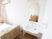 サムネイル 居室にある白い洗面台は、車椅子でのご利用に対応している。鏡は、アーチ形で柔らかい印象を与える。居室にはエアコンも設置されている。
