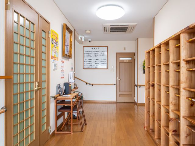 整った施設の廊下 廊下 広々とした廊下には、木製のシューズラックが設置され、使いやすさを考えた設計がなされています。