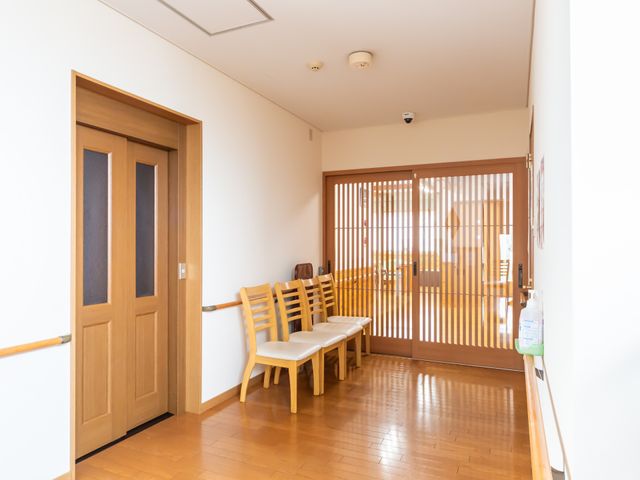 落ち着いた雰囲気の廊下 廊下 自然素材を活かした柔らかな照明の廊下です。椅子が設置され、小休憩がとりやすいです。