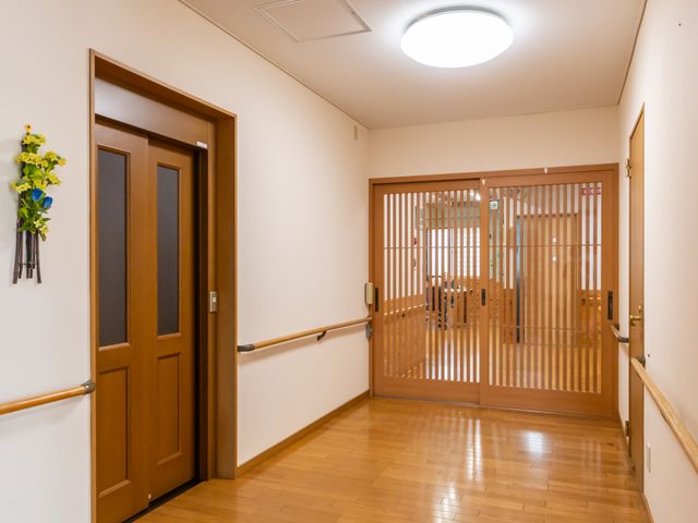 温かみのある廊下 廊下 温かみのある木製の手すりと扉が特徴的な廊下です。穏やかな空間が広がっています。