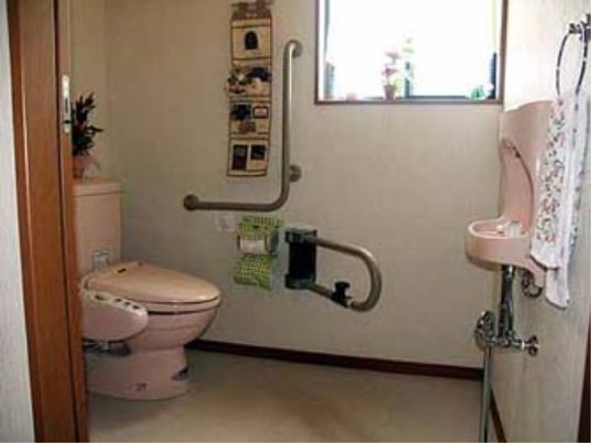 広めのゆったりとしたトイレである。窓から差し込む光も明るい。ピンク色の便座には温水洗浄機が付いている。