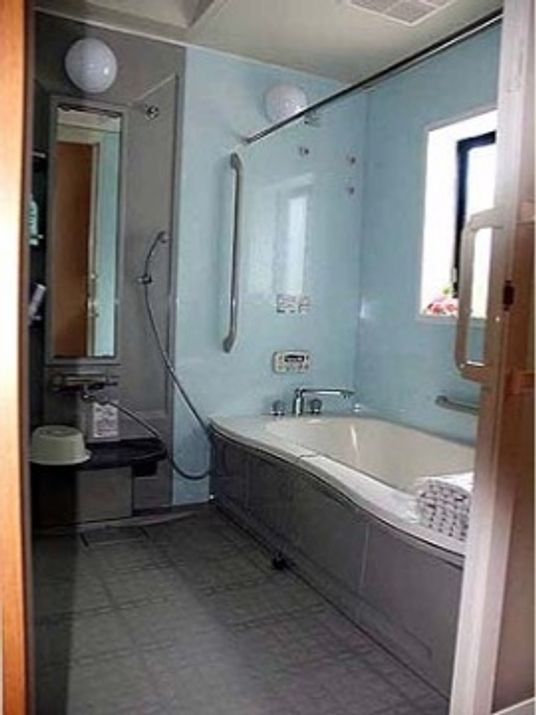 施設の写真 こぢんまりとした浴室で、足が伸ばせる長めの浴槽がある。浴槽の横には手すりが付いている。浴室乾燥機もある。