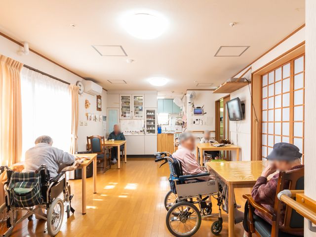温かみのある共有スペース 共有スペース ゆったりした雰囲気の食堂で、入居者の方々がくつろいでいる様子が印象的です。明るい窓辺での時間を楽しみませんか。