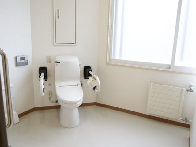 バリアフリー設計のトイレ 共用トイレ 手すり付きで広々とした清潔なトイレです。ご利用者様が安心してお使いになれる環境を整えています。