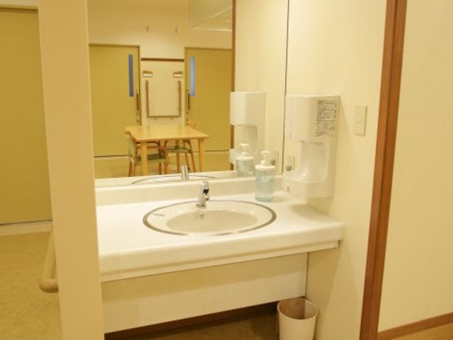 清潔な洗面所と背景の部屋 洗面台。 快適にお使いいただける洗面台が整った空間です。奥に見える部屋も含め、ご自身でのお手入れがしやすい環境をご覧いただけます。