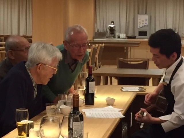 ギター演奏のレクリエーション 団らん 笑顔あふれる食堂で音楽のひとときを。スタッフによるギター演奏が、居心地の良い空間を演出しています。