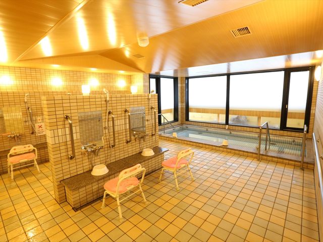 広々とした明るい浴室 大浴場 快適なケアを支援する広々とした浴室です。手すりや椅子も完備しており、安全にご利用いただけます。