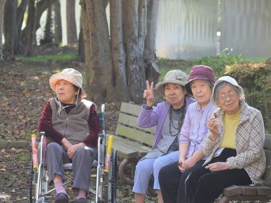 お年寄りがベンチに座る様子