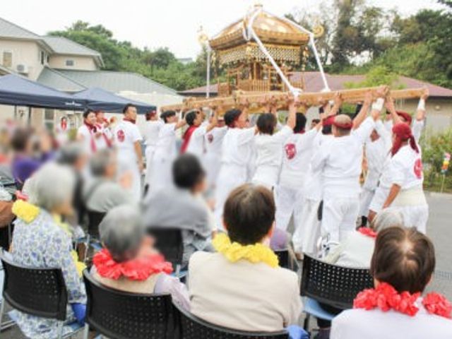 お祭りの様子の庭 庭 庭で行われているお祭りを楽しむ様子です。お仕事として地域交流に携わる機会を感じられます。