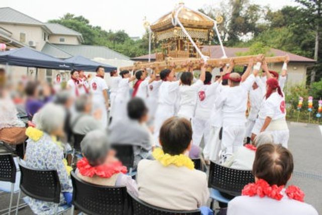お祭りの様子の庭 庭 庭で行われているお祭りを楽しむ様子です。お仕事として地域交流に携わる機会を感じられます。