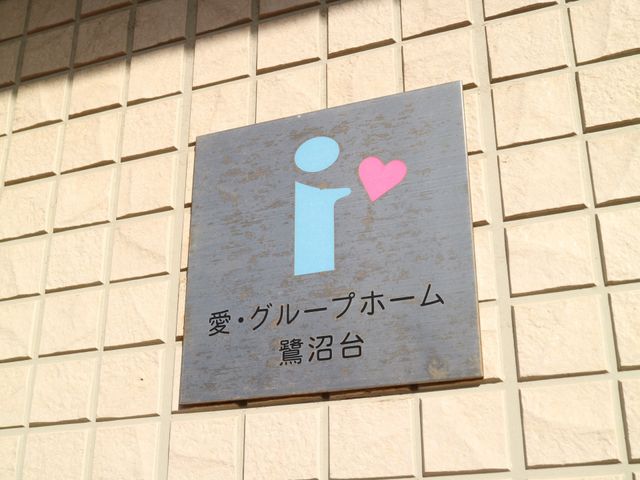 愛情ある看板のクローズアップ 看板 あたたかみのあるデザインの看板が、潜在スタッフへようこその気持ちを伝えます。ケアを通じた心のつながりを大切にした環境です。