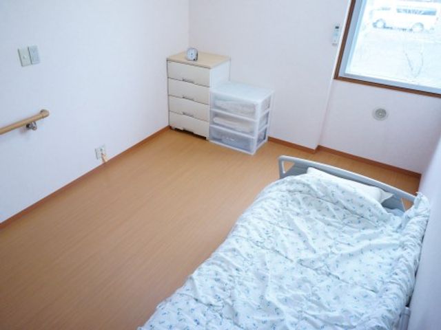 清潔な個室の一角 居室 シンプルで清潔感のある居室です。手すりや広々としたスペースが安心を提供します。