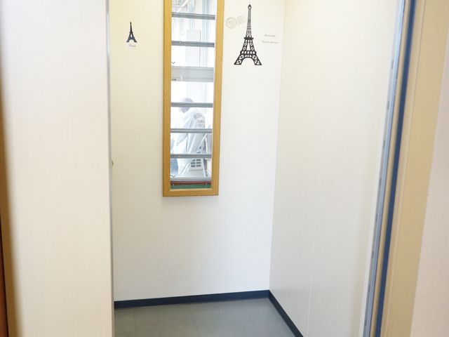 壁画装飾付き廊下の角 白いエレベーター 温かみのある装飾が施された廊下です。アクセントとなる壁画が、日々の通行を楽しいひとときに変えてくれます。