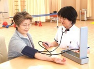 血圧測定する利用者と職員